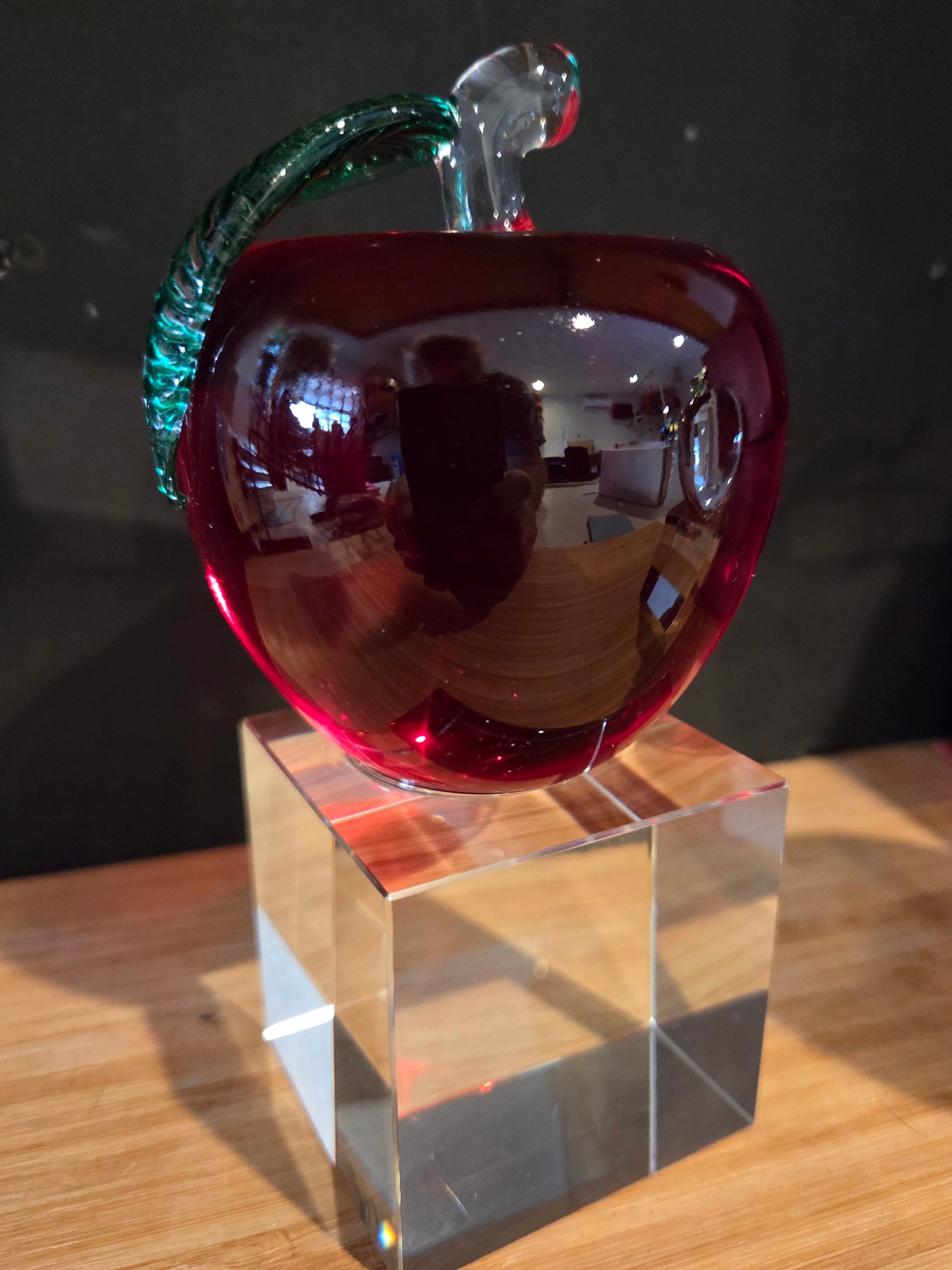 Red glass apple with green base on a clear crystal block