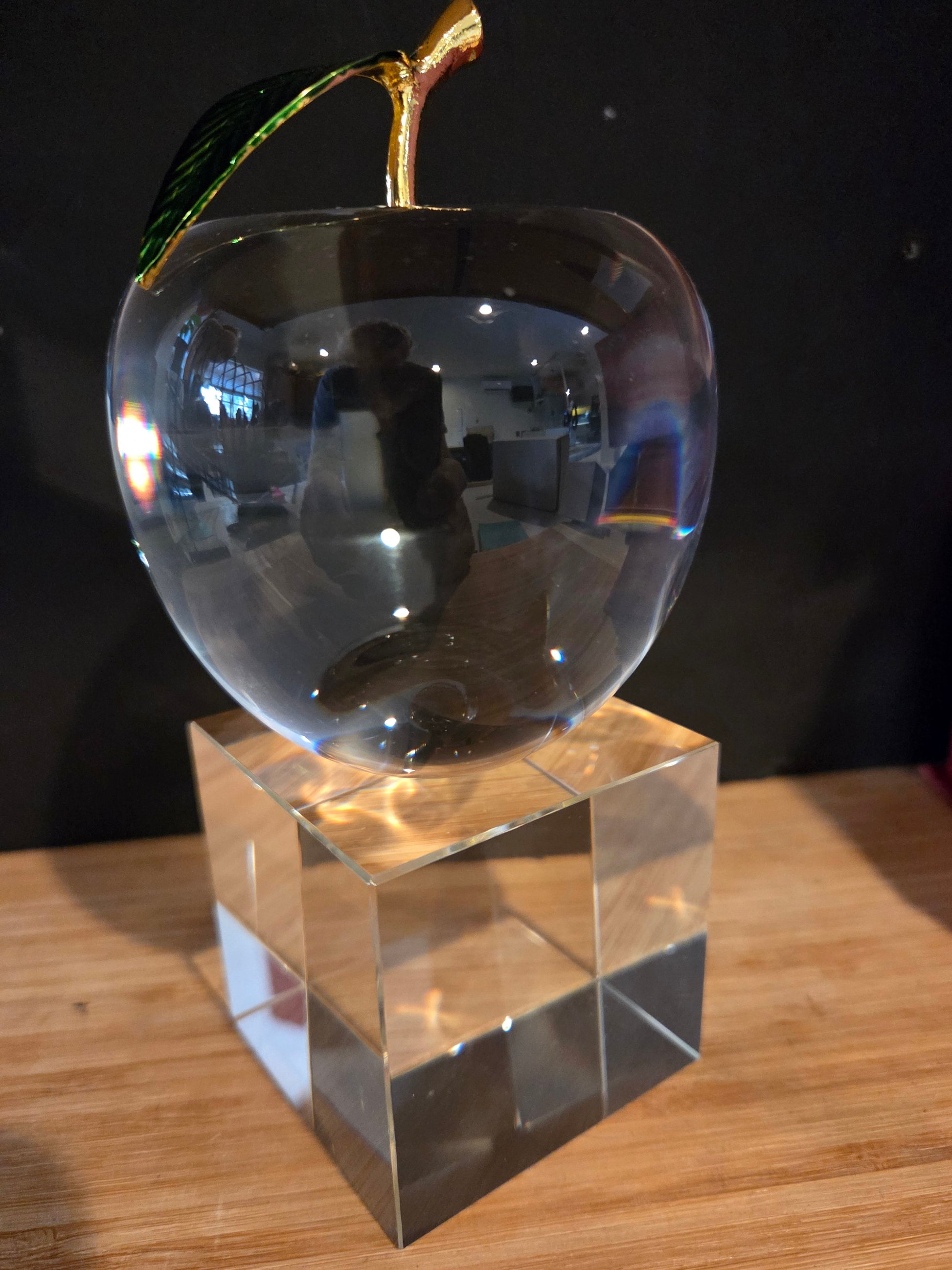 Clear crystal heart-shaped object and cube on a reflective surface